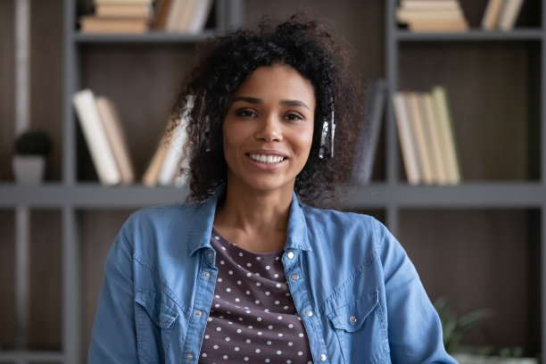 友好的美国黑人成年学生女孩在无线耳机图片下载