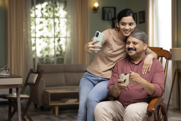 女儿和父亲一起在家里拍股票照片图片下载