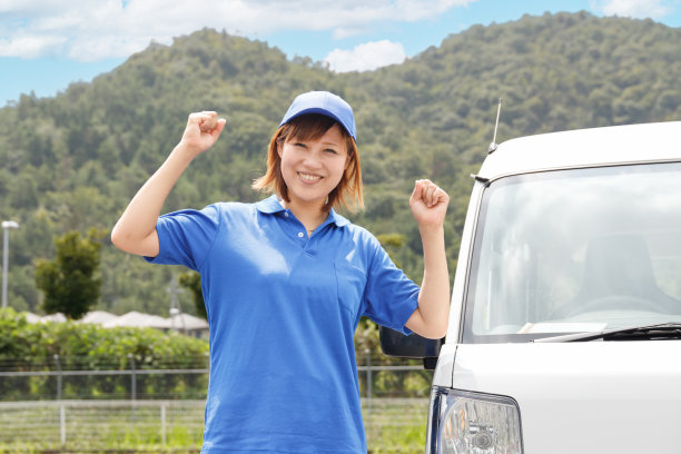 一个穿着polo衫，开着轻型卡车的快乐女人。在移动和交通运输行业工作的形象。图片下载