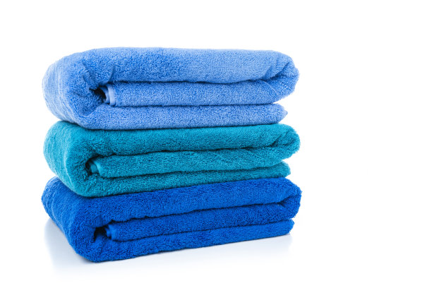 三条新的蓝色毛巾堆叠在白色背景上图片下载