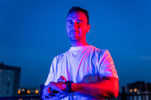 年轻男子在霓虹灯下使用智能手表的肖像图片下载