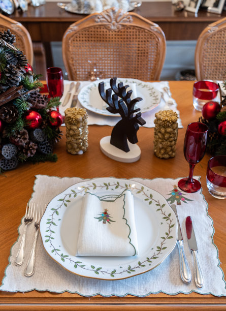 空的圣诞餐桌概览，大流行期间空的圣诞餐桌，圣诞主题餐桌，装饰圣诞树和木鹿，餐桌上的圣诞装饰图片下载