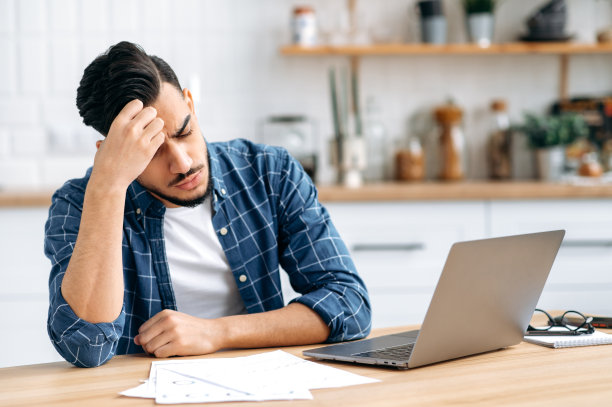 悲伤的阿拉伯人或印度人，坐在办公桌前，看起来疲惫和压力，沮丧地看着工作图表，未能按时完成项目，需要休息。工作过度，最后期限图片下载