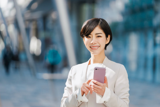 西装革履的女人拿着智能手机图片下载
