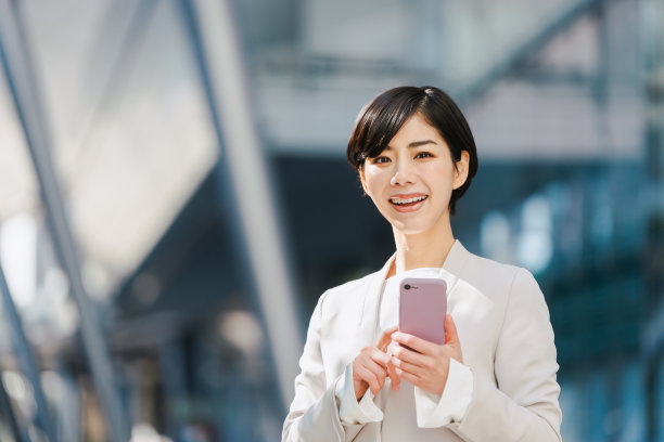 西装革履的女人拿着智能手机图片下载
