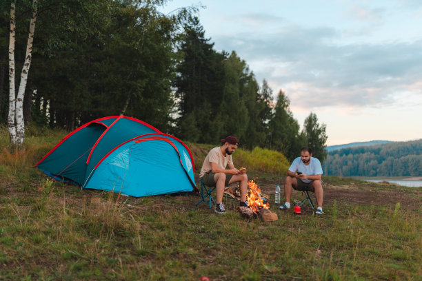 两个年轻的徒步旅行者在户外露营，在篝火旁聊天图片下载