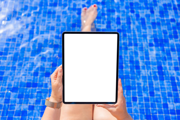 泳池边的女人手里拿着平板电脑，屏幕是白色的图片下载