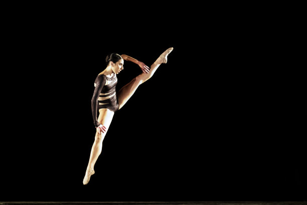 女孩在黑暗的舞台上表演现代舞图片下载
