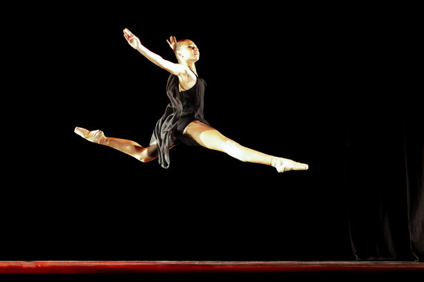 女孩在黑暗的舞台上跳新古典芭蕾图片下载