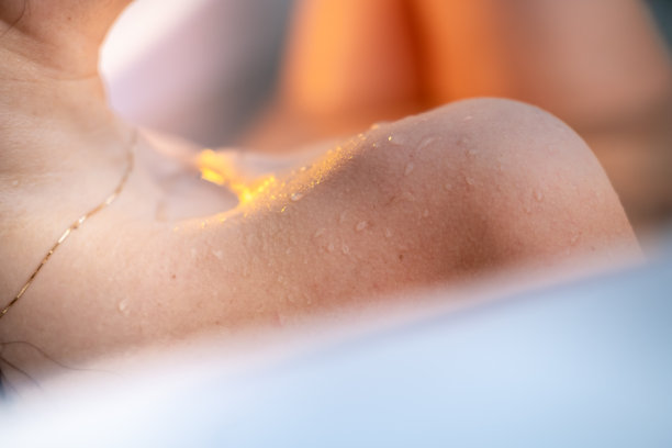 皮肤沾水，浴缸里一个女人肩膀的细节。图片下载