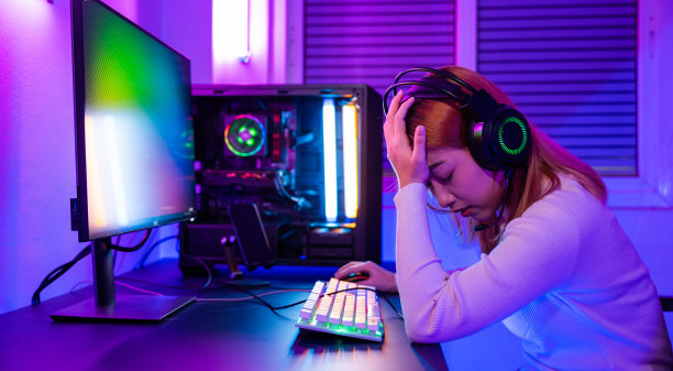 愤怒的亚洲玩家戴着游戏耳机玩操纵杆游戏机图片下载