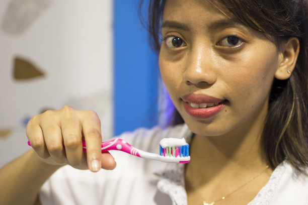 美丽的亚洲女人使用牙刷图片下载
