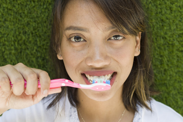 美丽的亚洲女人使用牙刷图片下载