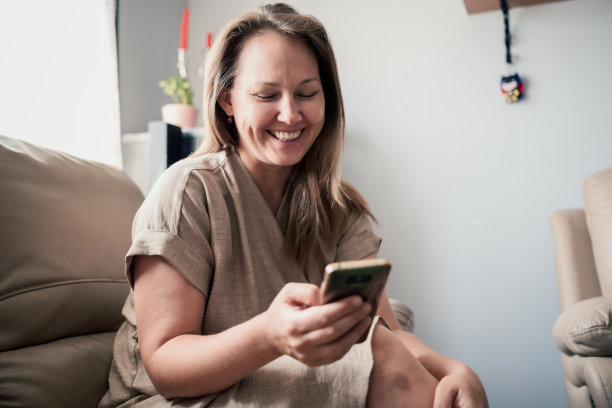 快乐的女人使用智能手机，交易和加密货币概念在线检查她的收入图片下载