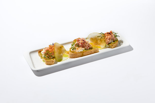 白色墙壁上白色背景的蟹烤面包构成美学。意大利烤面包配蟹肉、牛油果和奶酪，是夏日美食。优雅的菜单的概念。图片下载