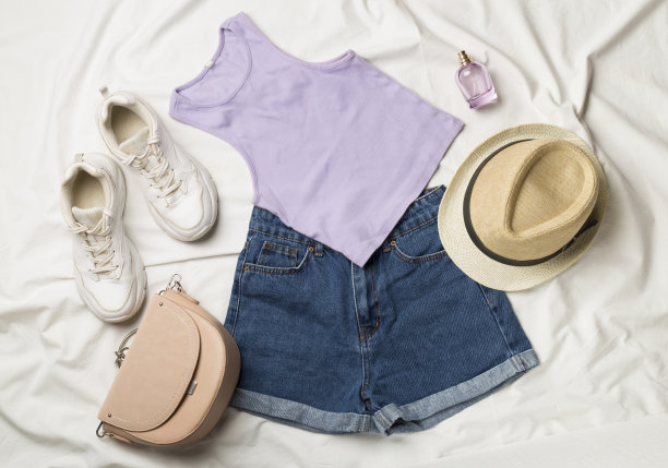 平铺与女性休闲服装在白色床单上，俯视图图片下载