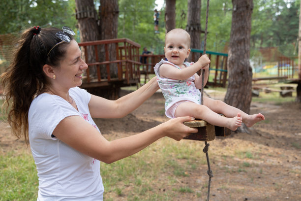 母亲在绳索公园骑着她的孩子。图片下载