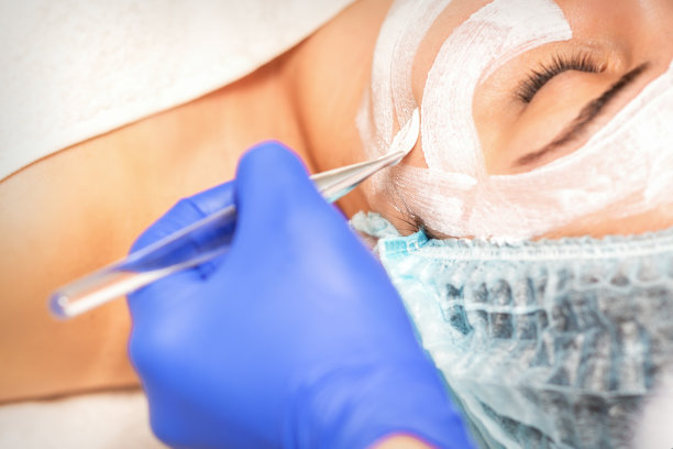 在美容师面前脱皮。面部护理。美容师给女病人敷了一个洁面面膜。图片下载