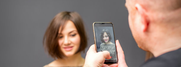 美发师在黑色背景下拍摄了一位剪完短发的女士。图片下载