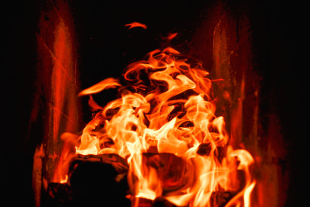 在石炉中燃烧木柴和煤炭。砖炉放在木头上。燃烧的火焰的长舌头图片下载