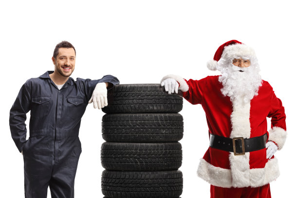 汽车修理工和圣诞老人拿着一堆轮胎摆造型图片下载