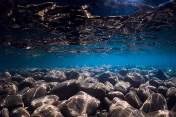 水下背景与石头和反射在蓝色的海水。图片下载
