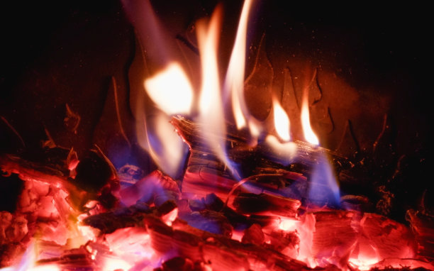 火在壁炉与玻璃特写。木柴在壁炉里燃烧。图片下载