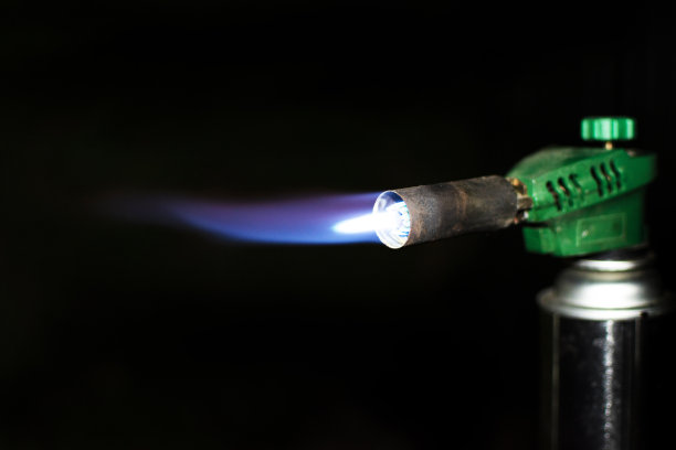 黑色背景上有一个燃烧的燃烧器的便携式气瓶图片下载