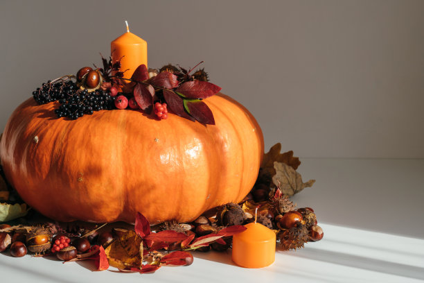 秋季装饰用南瓜，蜡烛和干燥的叶子特写。秋天还是感恩节的概念。秋天的装饰。图片下载