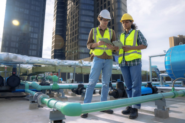 一组工程师正在检查大型建筑物或工业厂房的空调冷却系统。图片下载