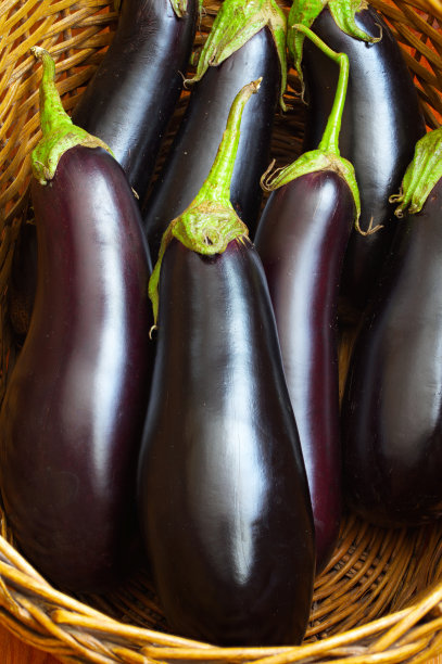 新鲜的紫茄子放在草筐里。图片下载
