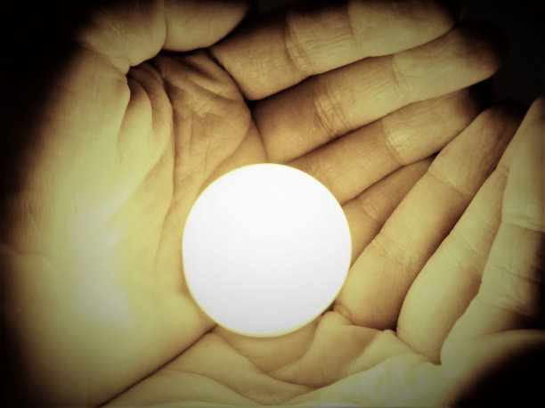 手握着发光的球体图片下载