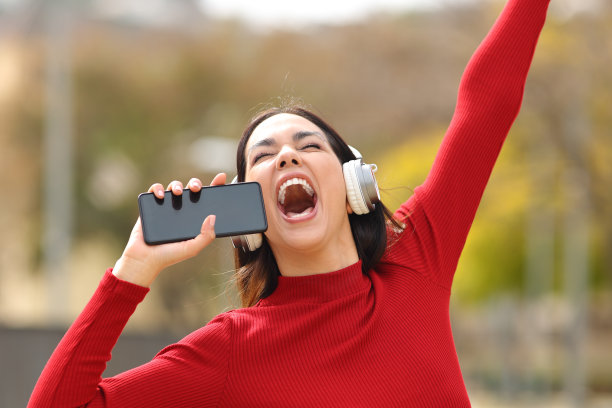 快乐的女人在街上听着音乐唱歌图片下载