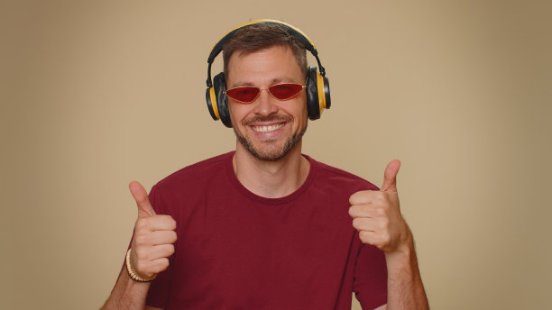 快乐英俊放松的男人听音乐，戴着耳机，跳迪斯科，闲逛，有乐趣图片下载