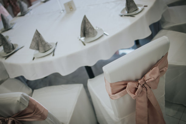 餐桌与白色，干净的盘子和桌子与蝴蝶结装饰的婚礼宴会图片下载