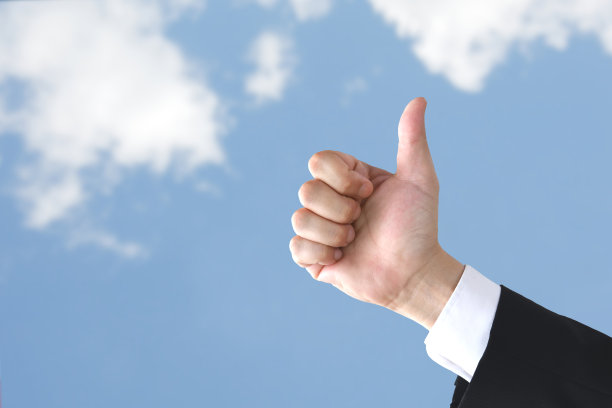 商人的大拇指放在蓝天背景上图片下载
