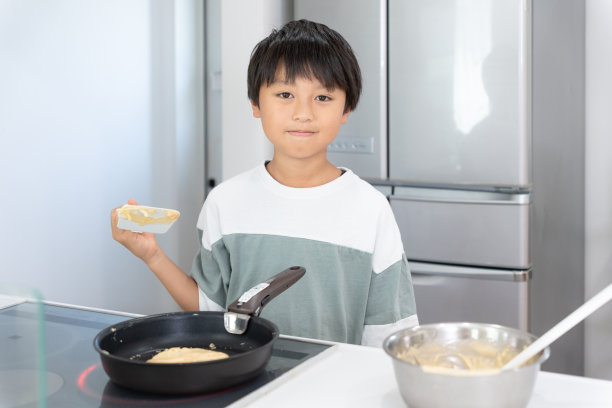 亚洲男孩在家厨房做饭图片下载