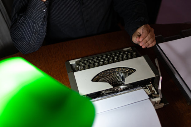 一个年轻人在长时间的工作后，晚上在他的家里在他的办公室打电话。图片下载