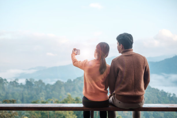 一对游客用手机拍照，博主看山景。一起旅行，度假，旅行，旅行和放松的概念图片下载