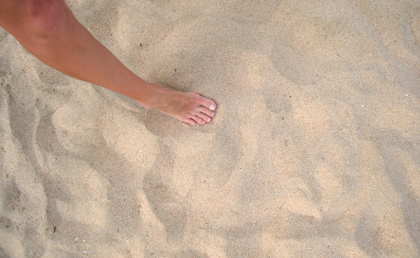 女性光脚站在沙滩上图片下载