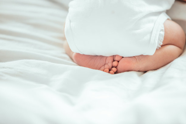 刚出生的婴儿睡在床上平静而甜蜜，腿和臀部特写图片下载