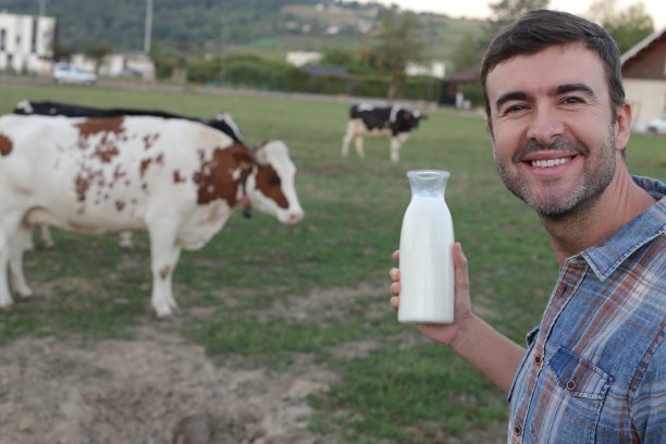 农民拿着新瓶装的牛奶图片下载