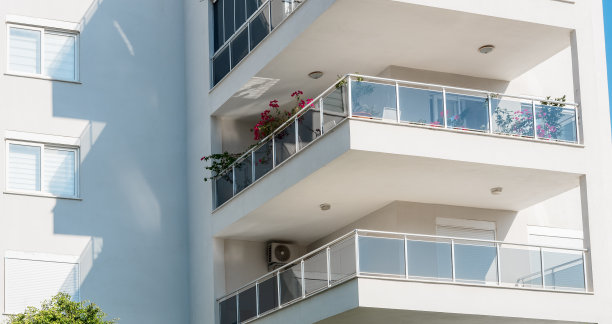 带阳台的白色居民楼立面特写。图片下载
