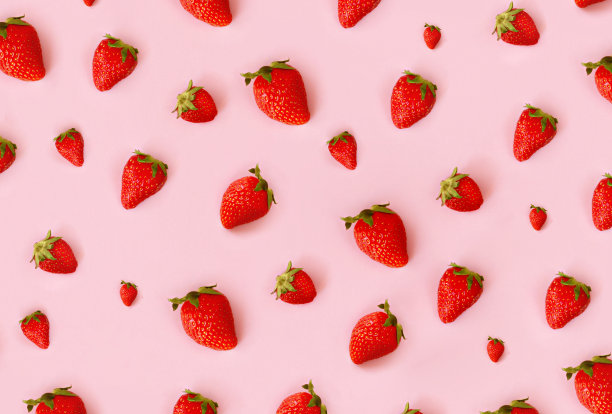 新鲜的红色草莓图案在粉红色的背景，俯视图。分散的浆果。创新食品的概念。图片下载