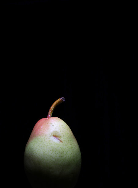 一个成熟的梨在黑色的背景图片下载