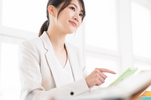 有吸引力的亚洲女人看智能手机，做生意图片下载