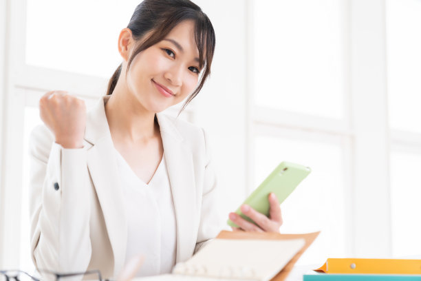 有吸引力的亚洲女人看智能手机，做生意图片下载