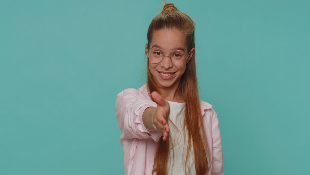 友好的少女向相机伸出手，提供握手，问候友好的微笑，欢迎图片下载