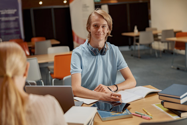 学生坐在图书馆做笔记，同时准备考试图片下载