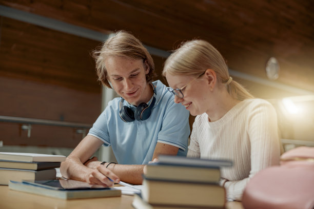 学生坐在图书馆做笔记，同时准备考试图片下载
